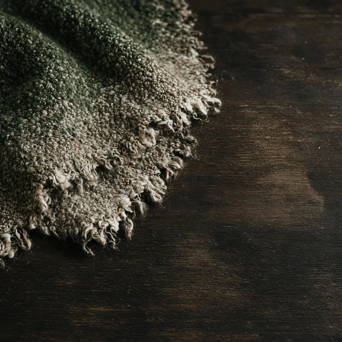 An illustrative close detail of wool laid across dark timber.