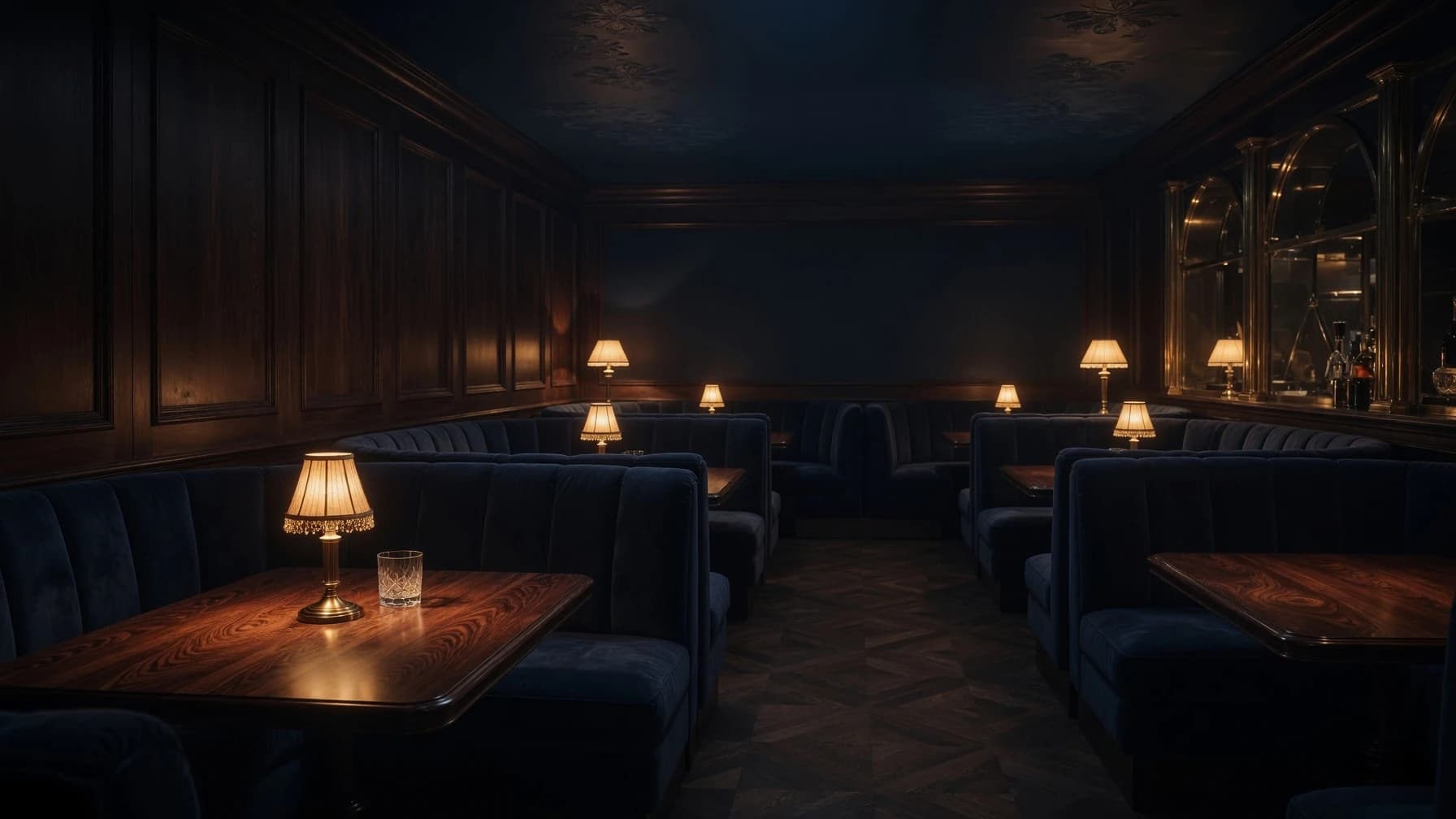 The room at Ush — booths in navy velvet, a lamp low on every table, no windows