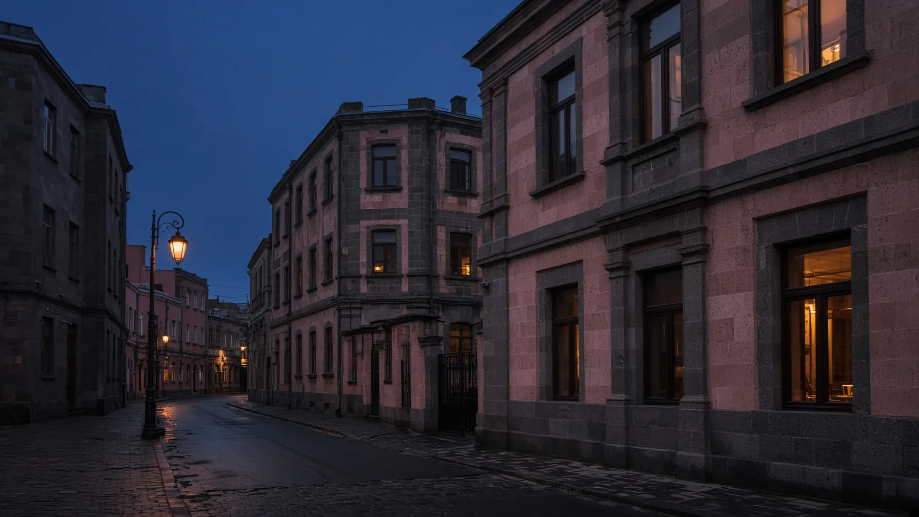 The side street at blue hour: pink tufa walls, lit windows and no signage on the door.